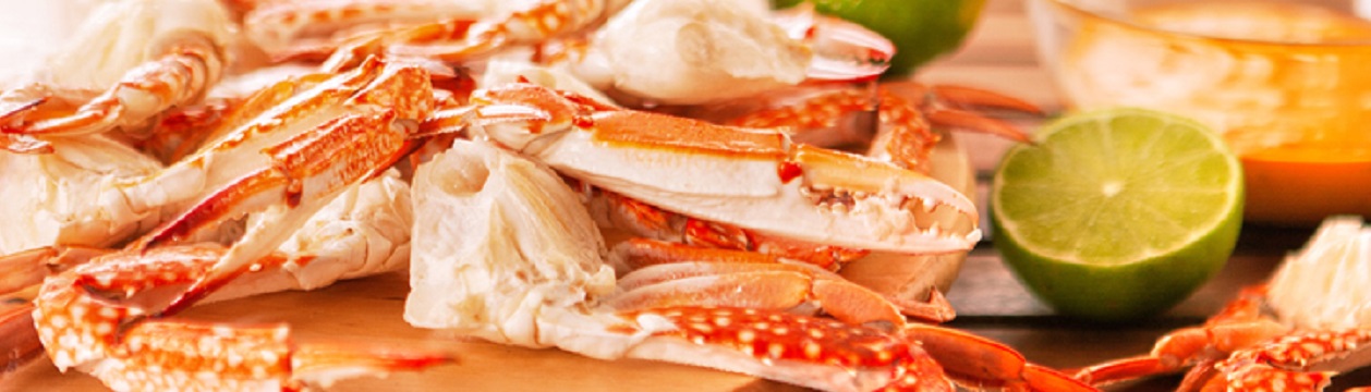 Blue grilled crabs with vegetables on wooden table